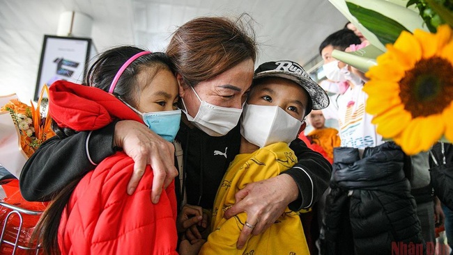 A Vietnamese citizen in Ukraine hugged her two grandchildren after arriving in Vietnam safely. (Photo: Thanh Dat)