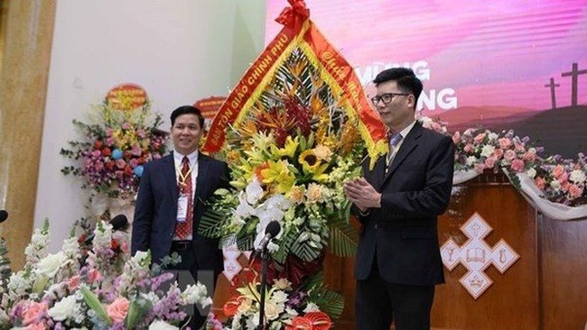 Nguyen Tien Trong (L), Vice Chairman of the Government Committee for Religious Affairs presents greeting flowers to the Evangelical Church of Vietnam (North) on the occasion of its 36th General Assembly 36th (Photo: VNA)