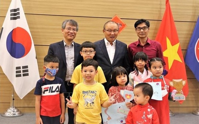 Ambassador Nguyen Vu Tung (left, behind) and coach Park Hang-seo (centre, behind) in a photo with Vietnamese children (Photo: VNA)