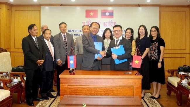 VJA Chairman Le Quoc Minh and LJA Chairman Savankhone Razmountry sign an agreement of cooperation between the two agencies.