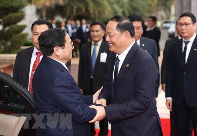 Prime Minister Pham Minh Chinh (L) welcomed by his Lao counterpart Sonexay Siphandone (Photo: VNA)