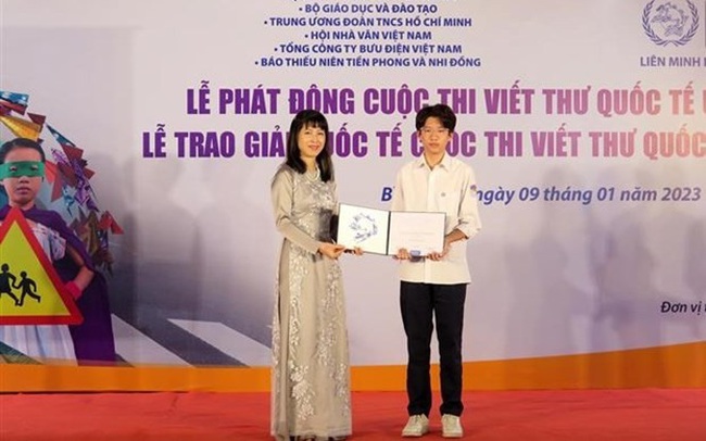 Nguyen Binh Nguyen (right), a ninth grader at Nguyen Tri Phuong High School in Hanoi receives a consolation prize of the 51st edition of the International Letter-Writing Competition for Young People in 2022. (Photo: VNA)
