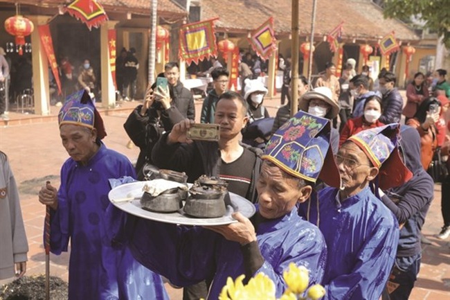 The rice-offering ritual is held before the village elders judge the winners. (Photo: VNA)