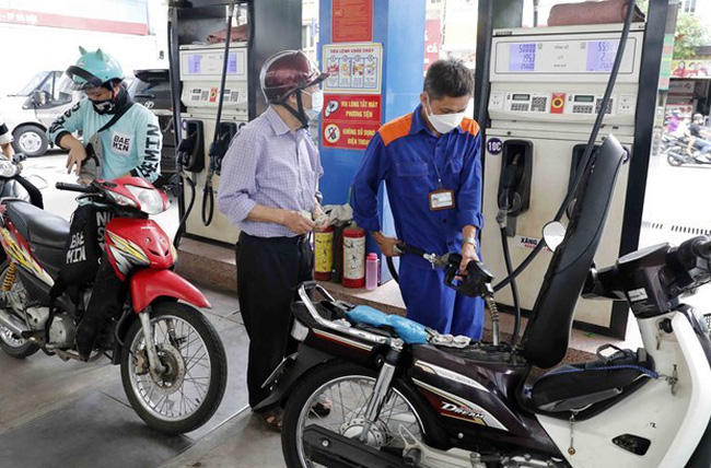 A man refills his motorbike at a petrol station in Hanoi. (Photo: VNA)