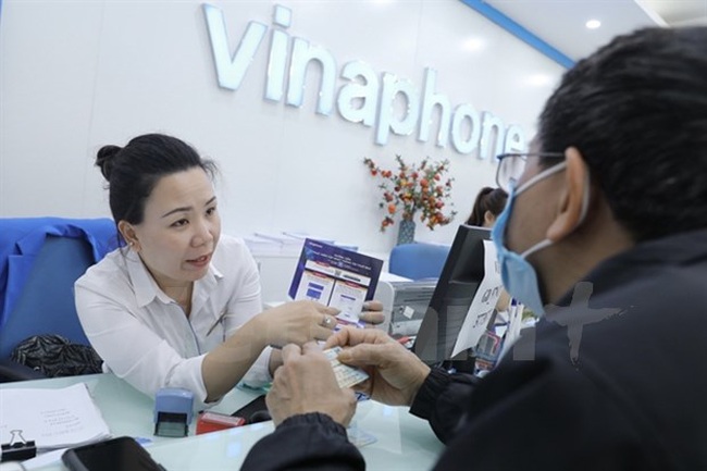 A VNPT worker guides a mobile phone subscriber to verify the information (Photo: VNA)