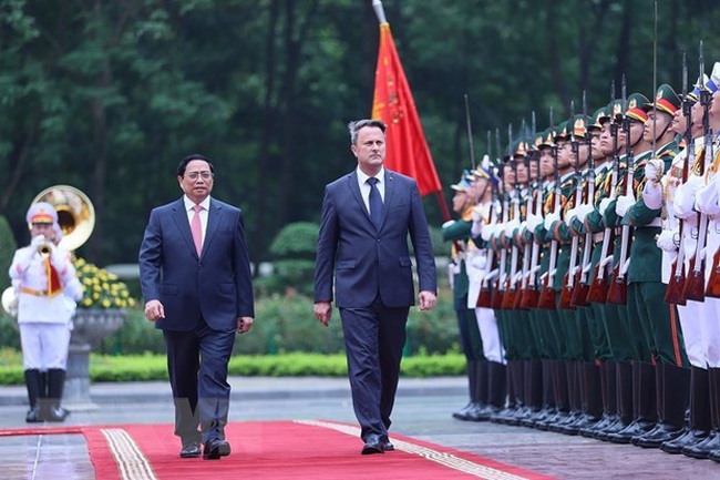 Prime Minister Pham Minh Chinh (L) and his Luxembourg counterpart Xavier Bettel review the guard of honour. (Photo: VNA)