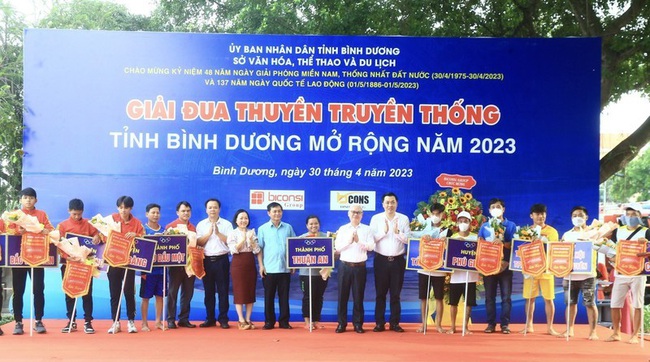 Secretary of Binh Duong Provincial Party Committee Nguyen Van Loi and other delegates present flags and flowers to the teams participating in the boat racing.