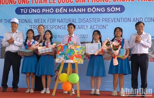 Delegates present awards to winners of a painting contest on disaster prevention.