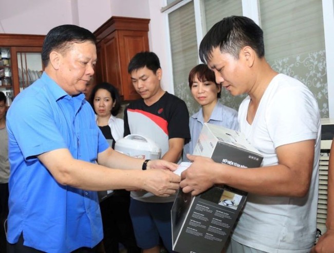 Secretary of Hanoi Party Committee Dinh Tien Dung gives essential items to fire victims in Thanh Xuan District.