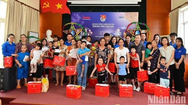 Members of the Youth Union of Nhan Dan Newspaper present gifts to disadvantaged children in Thanh Xuan District, Hanoi. (Photo: NDO)
