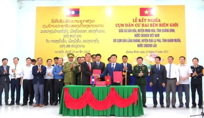 Representatives of Dan Hoa commune and Langkhang hamlet cluster sign a document to set up their twinning ties (Photo: VNA)