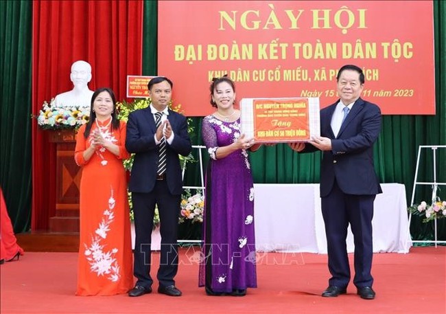 PCC Secretary Nguyen Trong Nghia (first, right) presents gifts to local authorities and peole of Co Mieu village at the event (Photo: VNA)