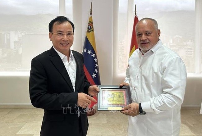 Vice Chairman of the CPV Central Committee’s Commission for Mass Mobilisation Nguyen Lam (L) presents a gift to PSUV First Vice President Diosdado Cabello Rondon. (Photo: Vietnamese Embassy in Venezuela)