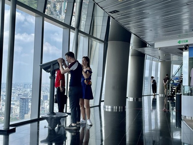 Foreign visitors enjoy the panoramic view of HCM City at the Saigon Skydeck. (Photo: VNA)