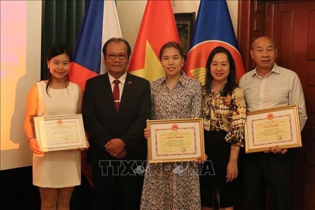 The Vietnamese Embassy in the Czech Republic presents certificates of merit to Vietnamese individuals who have made great contributions to community affairs and outstanding achievements in study and scientific research. (Photo: VNA)