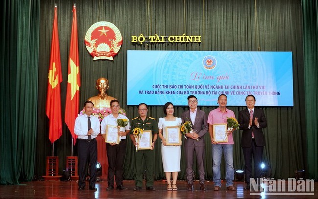 Deputy Minister of Finance Nguyen Duc Chi presents the first prizes to the winning reporters. (Photo: Trung Hung)