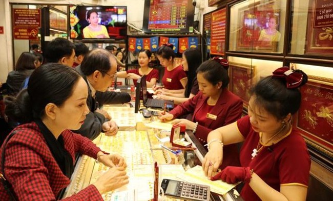 Customers make transactions at a Bao Tin Minh Chau gold shop. (Photo: VNA)