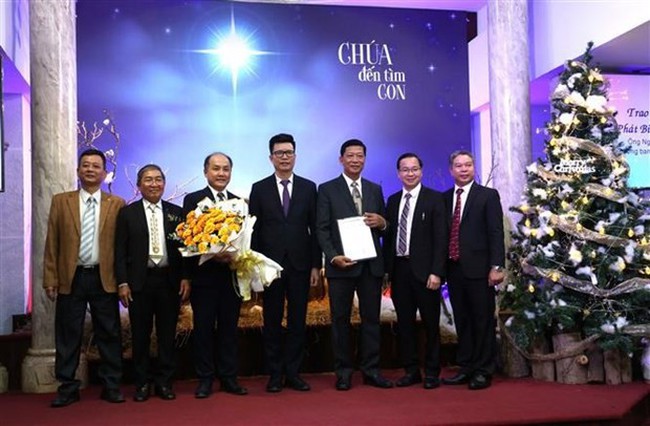Nguyen Tien Trong, Vice Chairman of the Government Committee for Religious Affairs (middle) hands over the decision approving the establishment the Vietnamese Baptist Theological Seminary to leaders of the Vietnam Baptist Convention on December 27. (Photo: VNA)