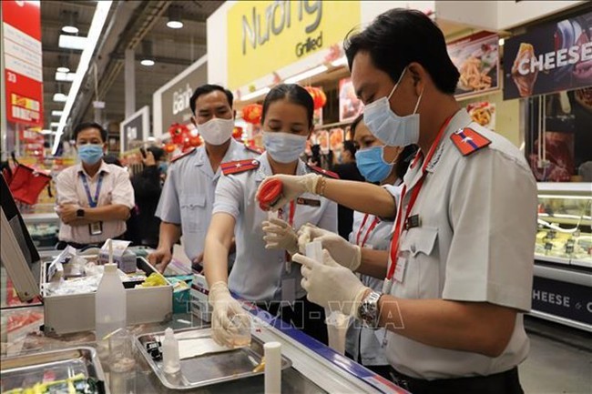 Food safety officials examine food at a restaurant. (Photo: VNA)