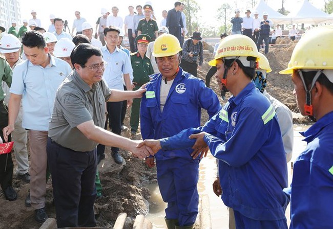 PM Pham Minh Chinh (left) meets workers of the Ring Road 3 project in HCM City on February 13. (Photo: VNA)