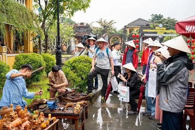 International tourists learn about the production process of handicraft products in Hoi An City on January 1. (Photo: TAN NGUYEN)