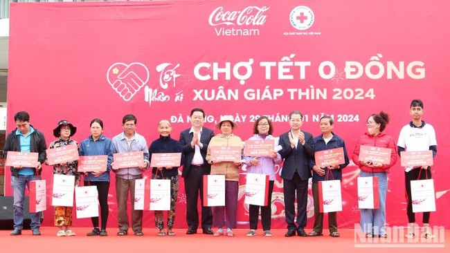Head of the PCC’s Commission for Communication and Education Nguyen Trong Nghia grants Tet gifts to needy households at the fair. (Photo: NDO)