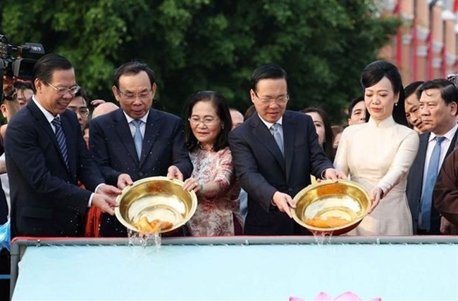 President Vo Van Thuong (second, right, front), his spouse and leaders of Ho Chi Minh City release carps as part of the “Ong Cong, Ong Tao” worshipping ritual. (Photo: VNA)