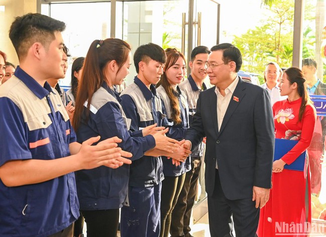 NA Chairman Vuong Dinh Hue presents gifts to workers of the JA Solar Vietnam Co. Ltd. in Bac Giang province on January 18. (Photo: NDO)