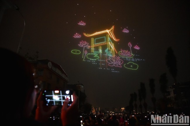 Hanoi residents and visitors admire the artistic light show using drones.