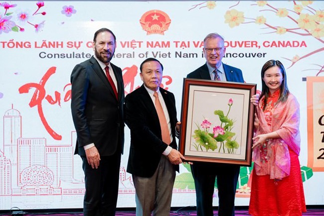 Consul General Nguyen Quang Trung (second, left) presents a gift to representatives of the British Columbia government. (Photo: VNA)