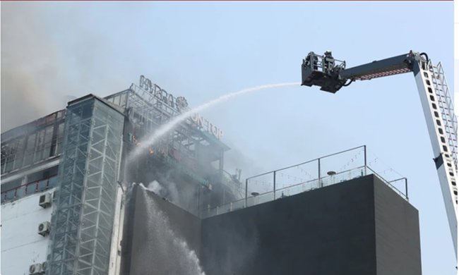 A ladder truck is used to put out the fire at a high-rise building at O Cho Dua intersection in Hanoi's Dong Da district on March 12 morning. (Photo: VNA)