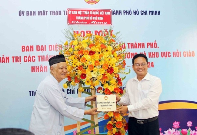 Vice President of Ho Chi Minh City's Vietnam Fatherland Front Committee Pham Minh Tuan presents flowers to a representative of the Muslim community in the city. (Photo: VNA)