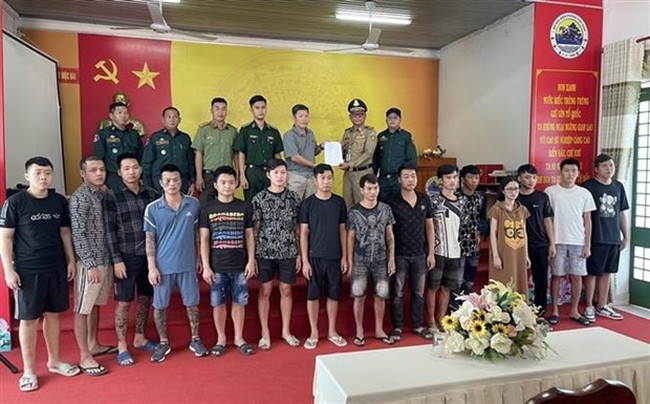Border guards at the Moc Bai international border gate in the southwestern province of Tay Ninh on March 12 receive 15 Vietnamese citizens. (Photo: VNA)