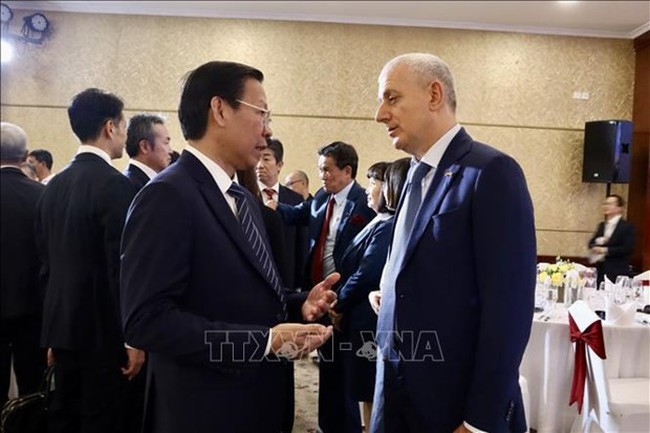 Chairman of the municipal People's Committee Phan Van Mai (L) talks to a delegate at the event (Photo: VNA)