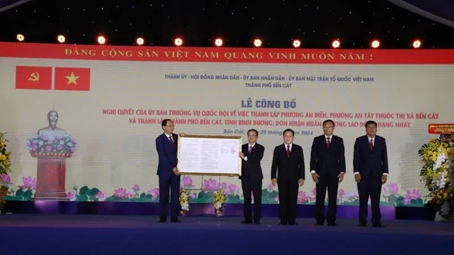 Vice Chairman of the National Assembly Tran Quang Phuong (left) hands over the decision on the establishment on Ben Cat city to the local authorities. (Photo: NDO)