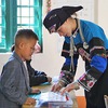 Young Bo Y ethnic teacher plants seeds of knowledge in children