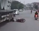 Vượt xe thiếu quan sát, cô gái đi xe máy suýt chui gầm container