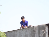 Giải cứu thanh niên nghi ngáo đá trèo lên nóc nhà dân ở TP.HCM