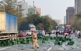 Cảnh sát giao thông cùng người dân thu dọn hàng trăm chai bia rơi xuống đường