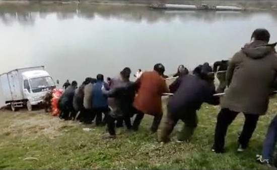 Trung Quốc: Hàng chục người chung tay kéo xe tải khỏi rơi xuống bờ sông