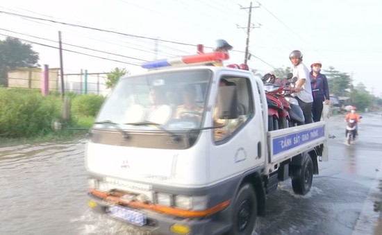 Công an Vĩnh Long chở xe máy giúp dân qua đoạn Quốc lộ ngập sâu