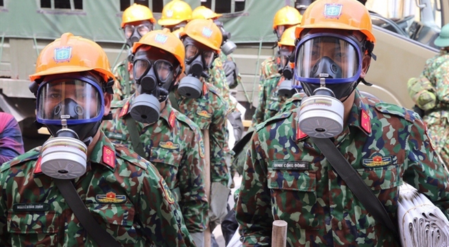 Soldiers remove toxic substances at Rạng Đông burnt warehouse